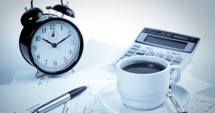 Pen, chart, calculator, alarm clock and cup of coffee. Business still-life.